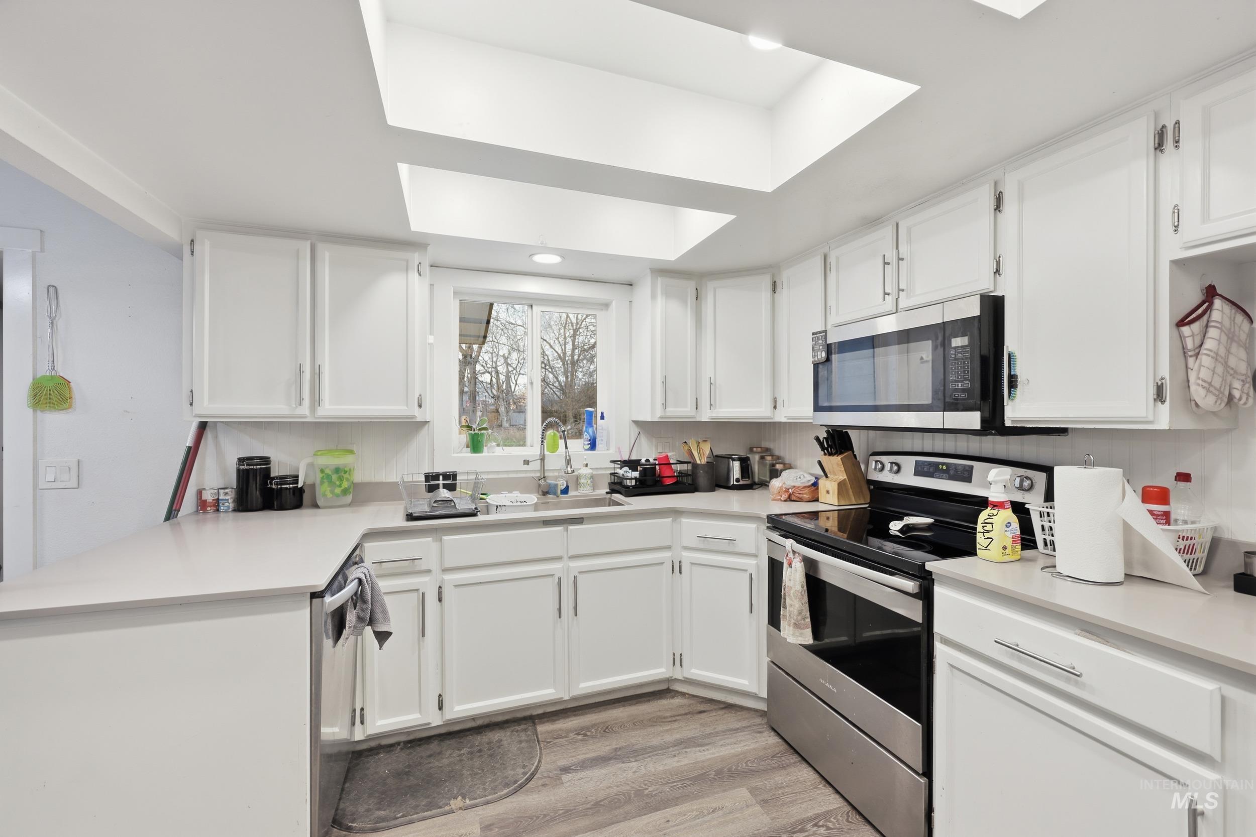 Kitchen featuring appliances with stainless steel finishes and white cabinets