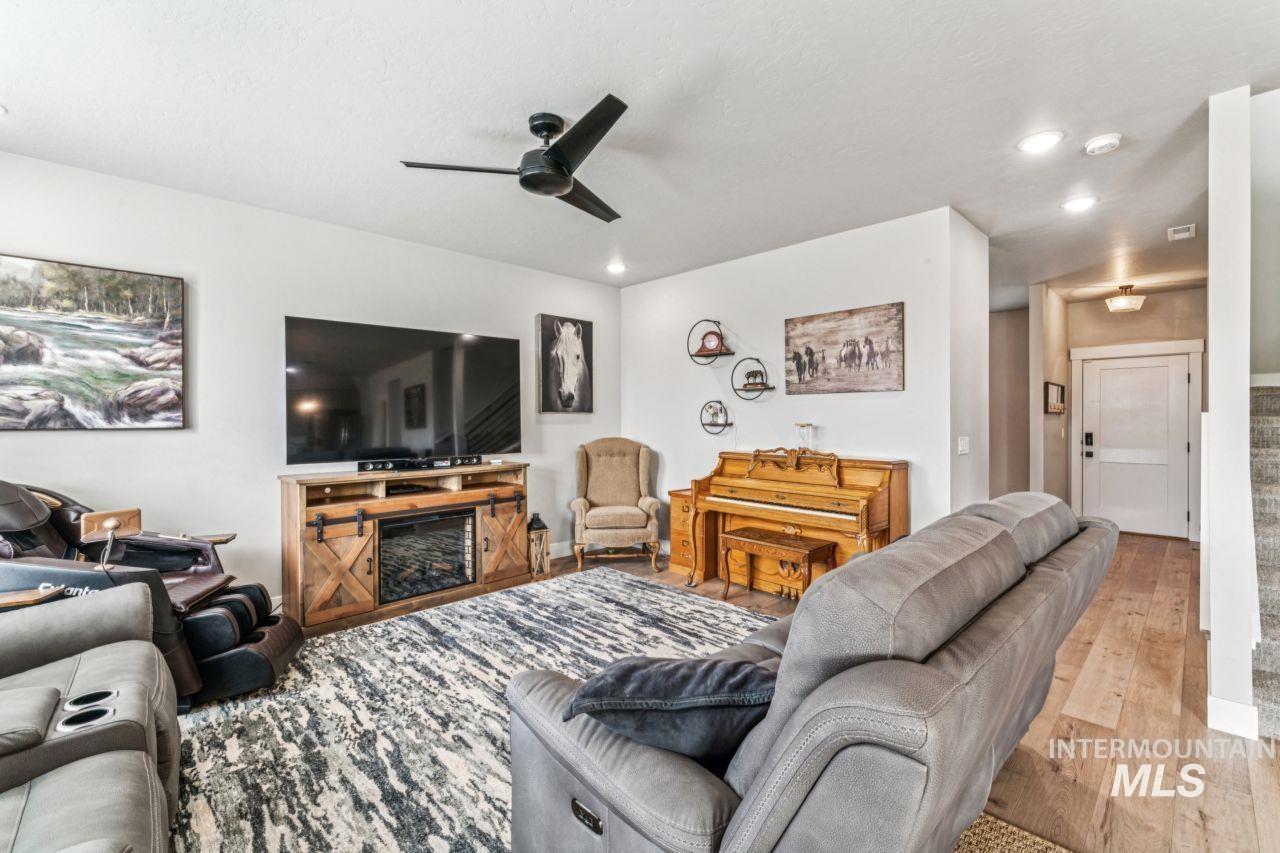 Living room featuring hardwood / wood-style flooring, stairway, recessed lighting, and ceiling fan