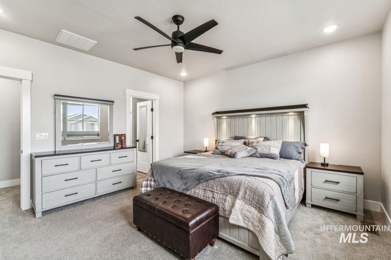 Bedroom with light colored carpet, a ceiling fan, and recessed lighting
