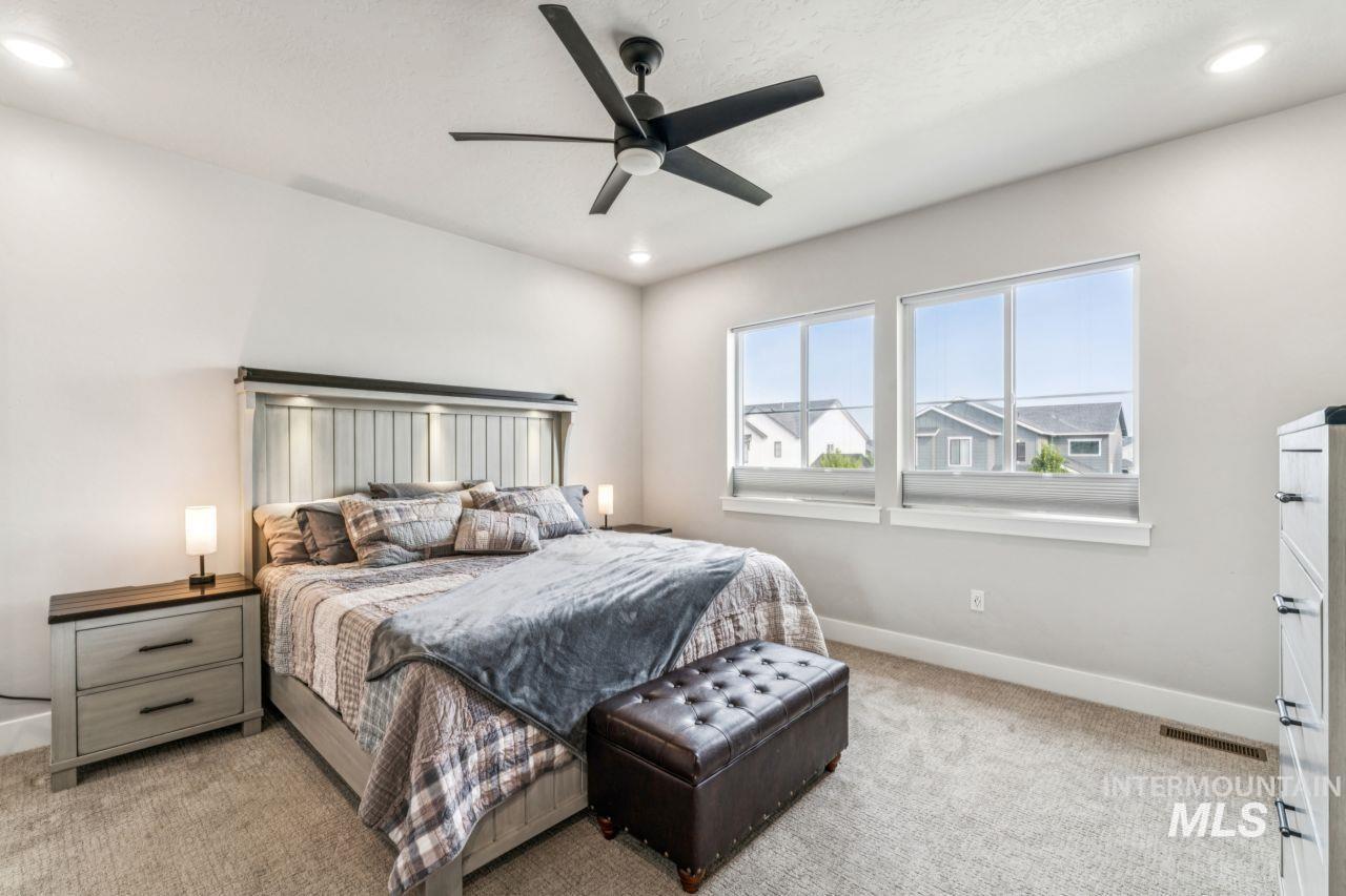 Bedroom featuring light carpet, a ceiling fan, and recessed lighting