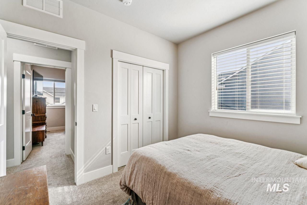 Bedroom with light colored carpet and a closet