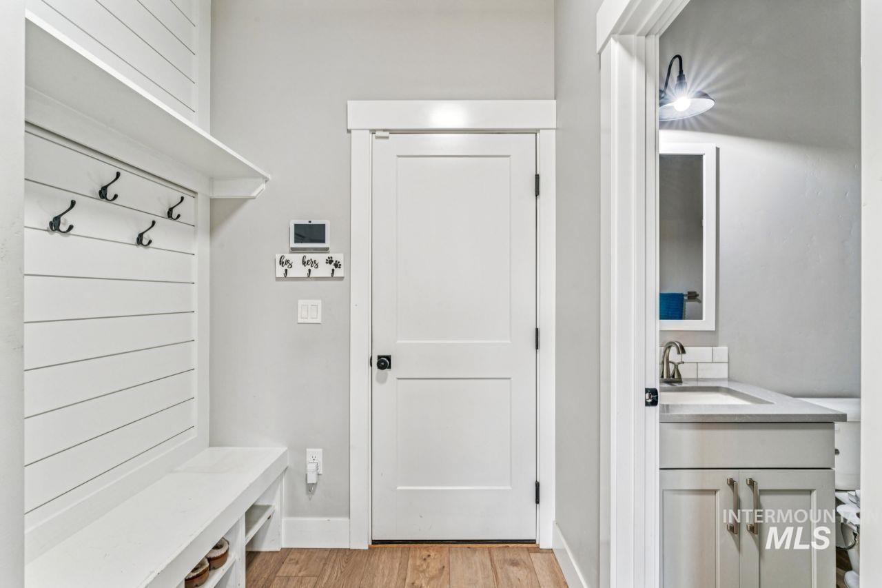 Mudroom with light wood-style floors and a sink