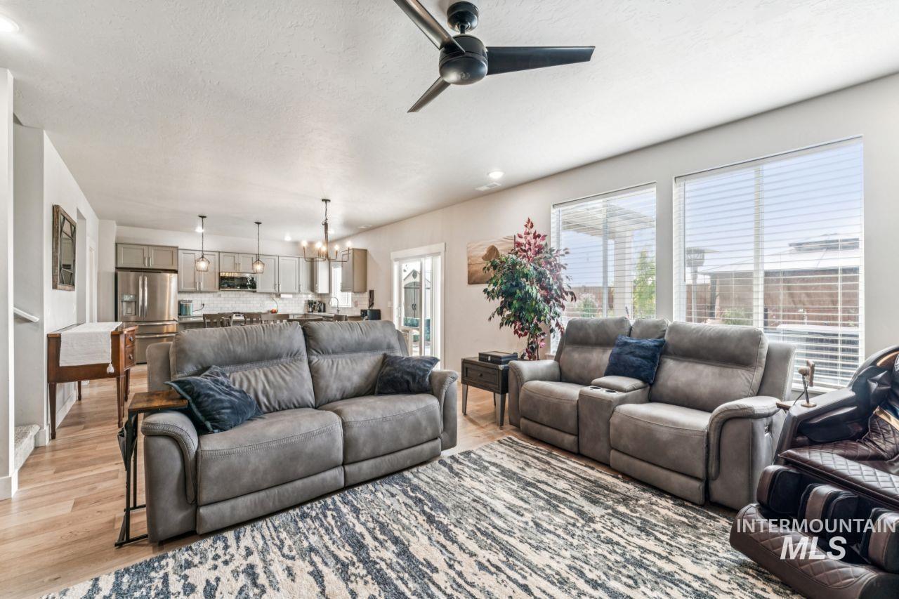 Living area featuring a chandelier, a ceiling fan, recessed lighting, and wood finished floors