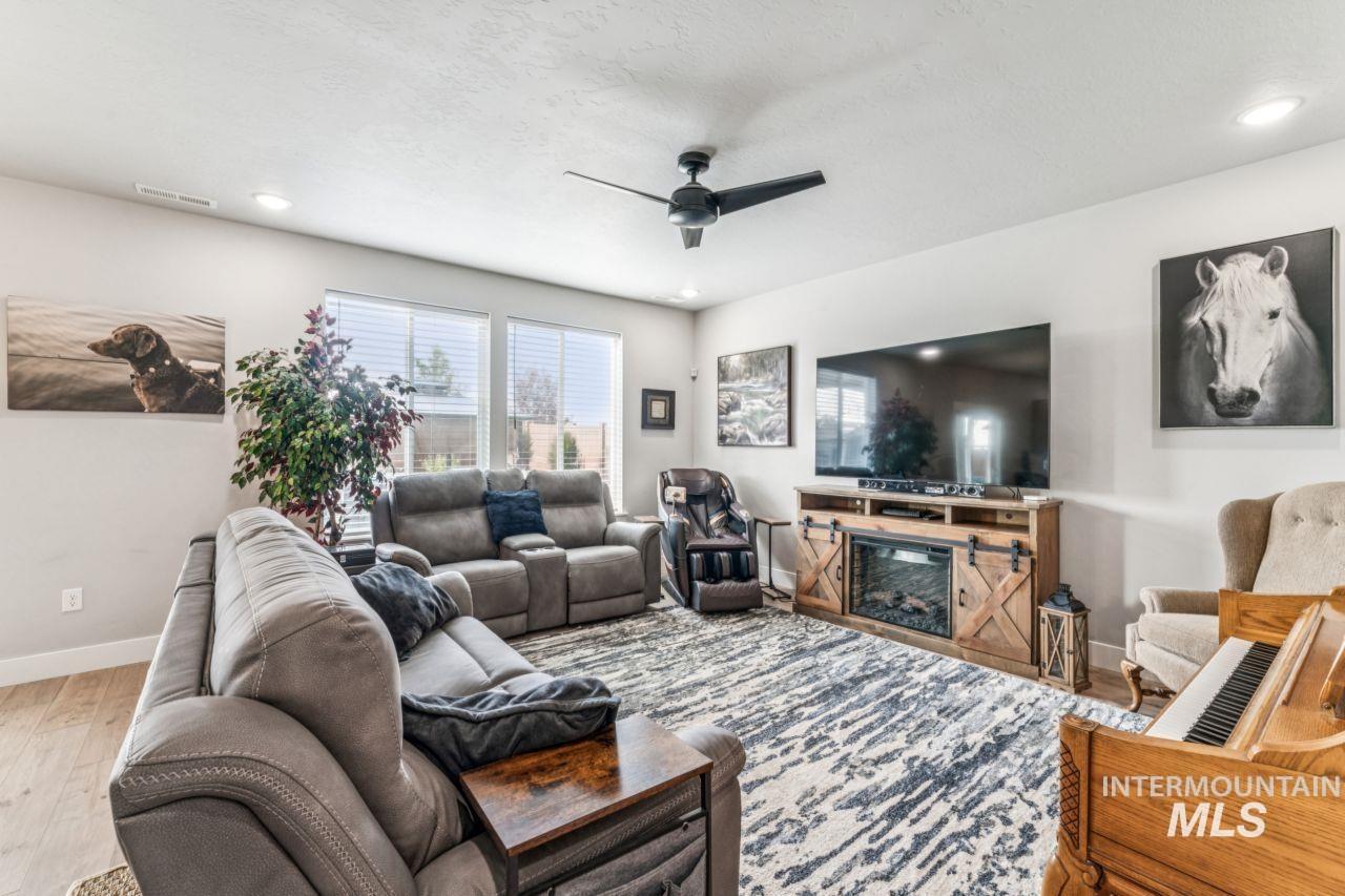 Living area with a ceiling fan, recessed lighting, and light wood-style flooring