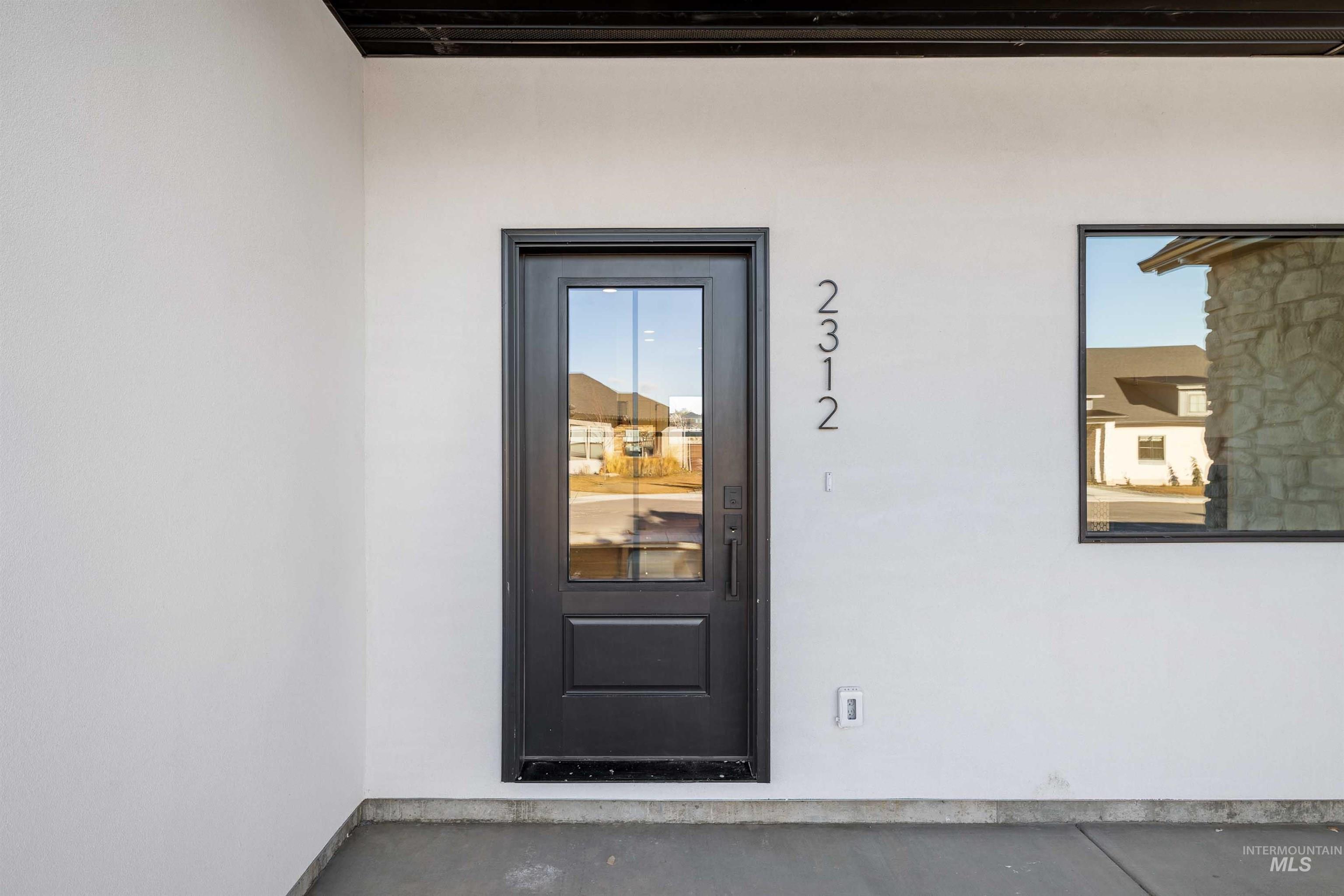 Doorway to property featuring stucco siding