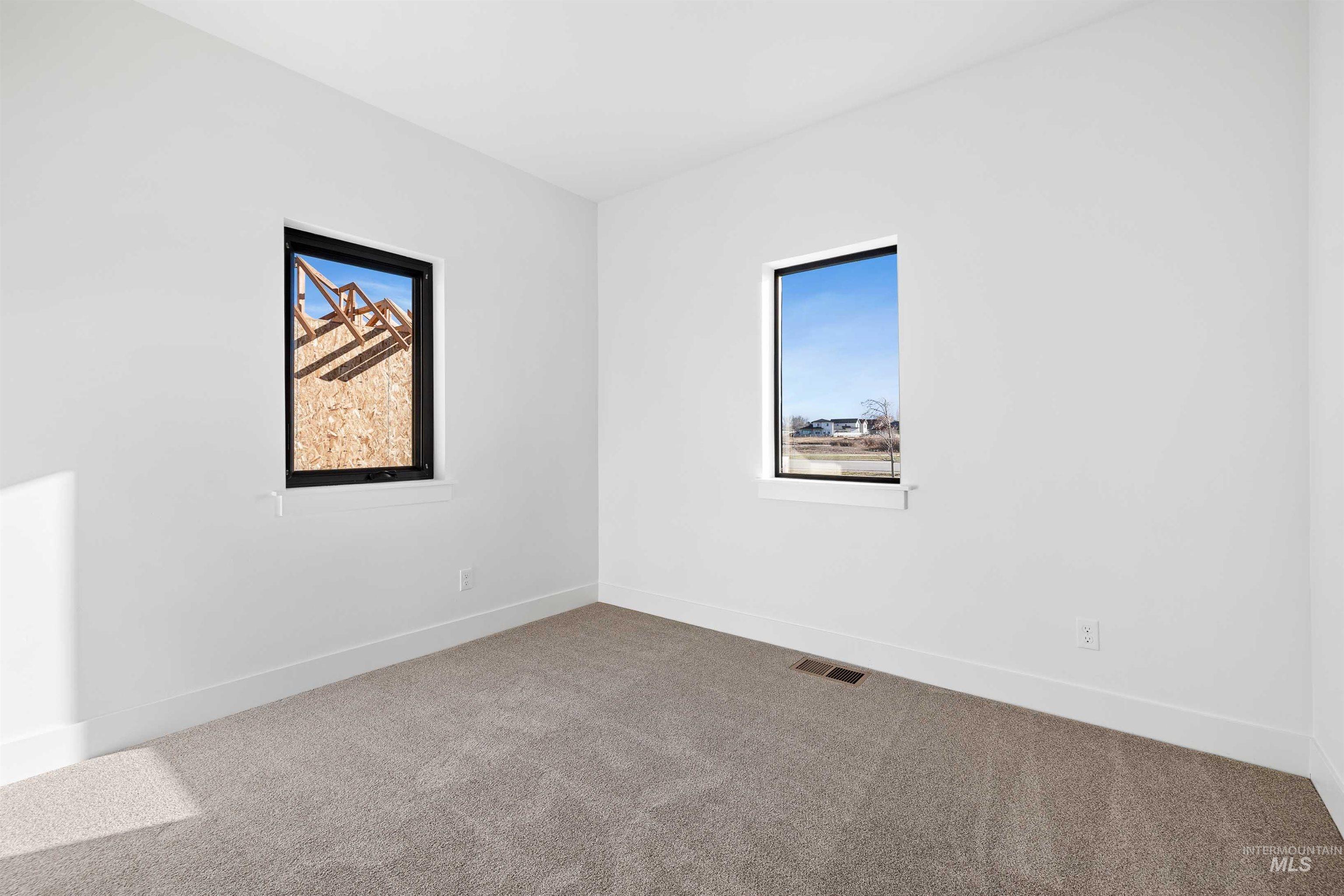 Empty room featuring carpet and plenty of natural light