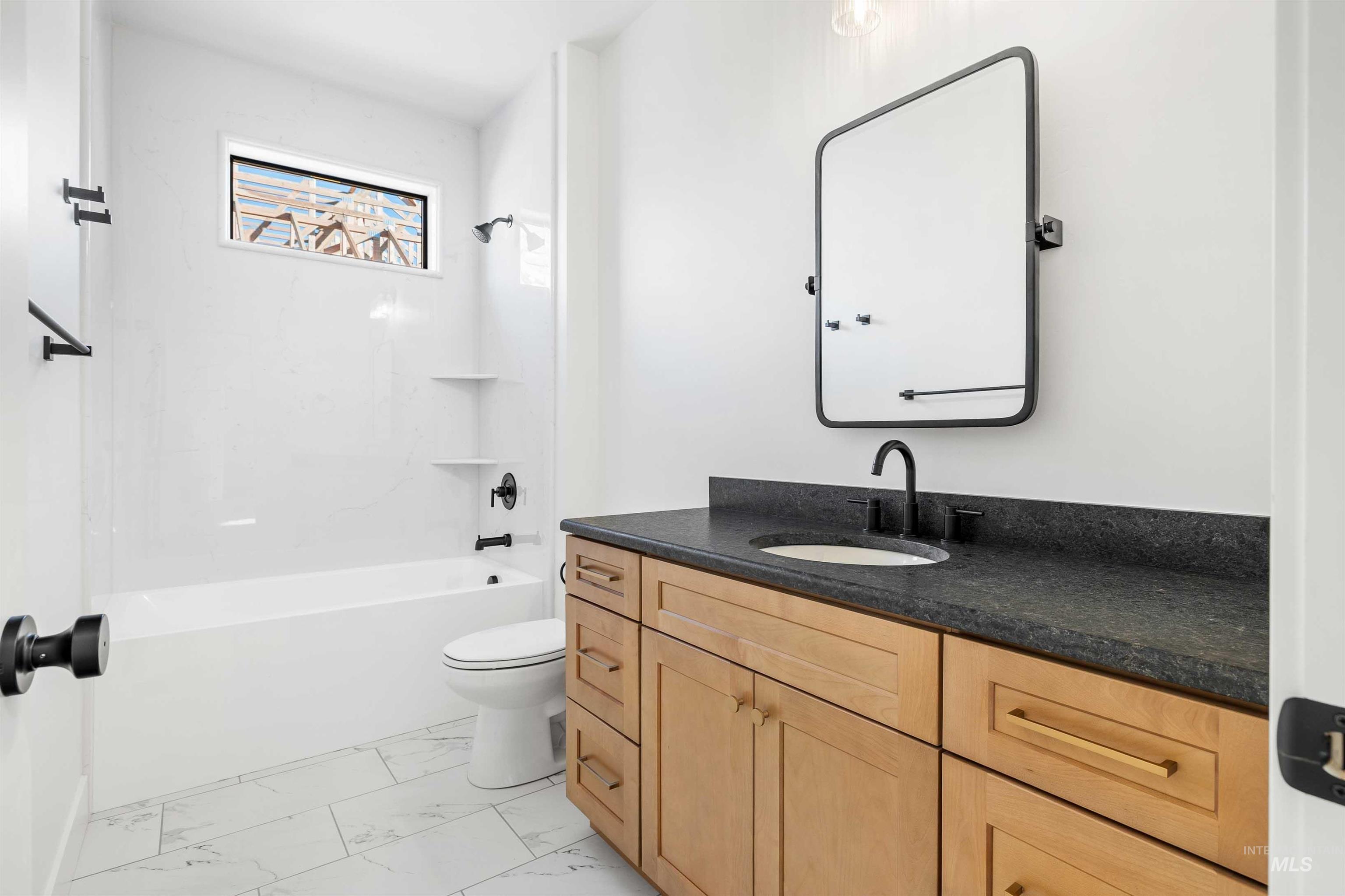 Full bath featuring vanity, shower / bathtub combination, and light marble finish floors