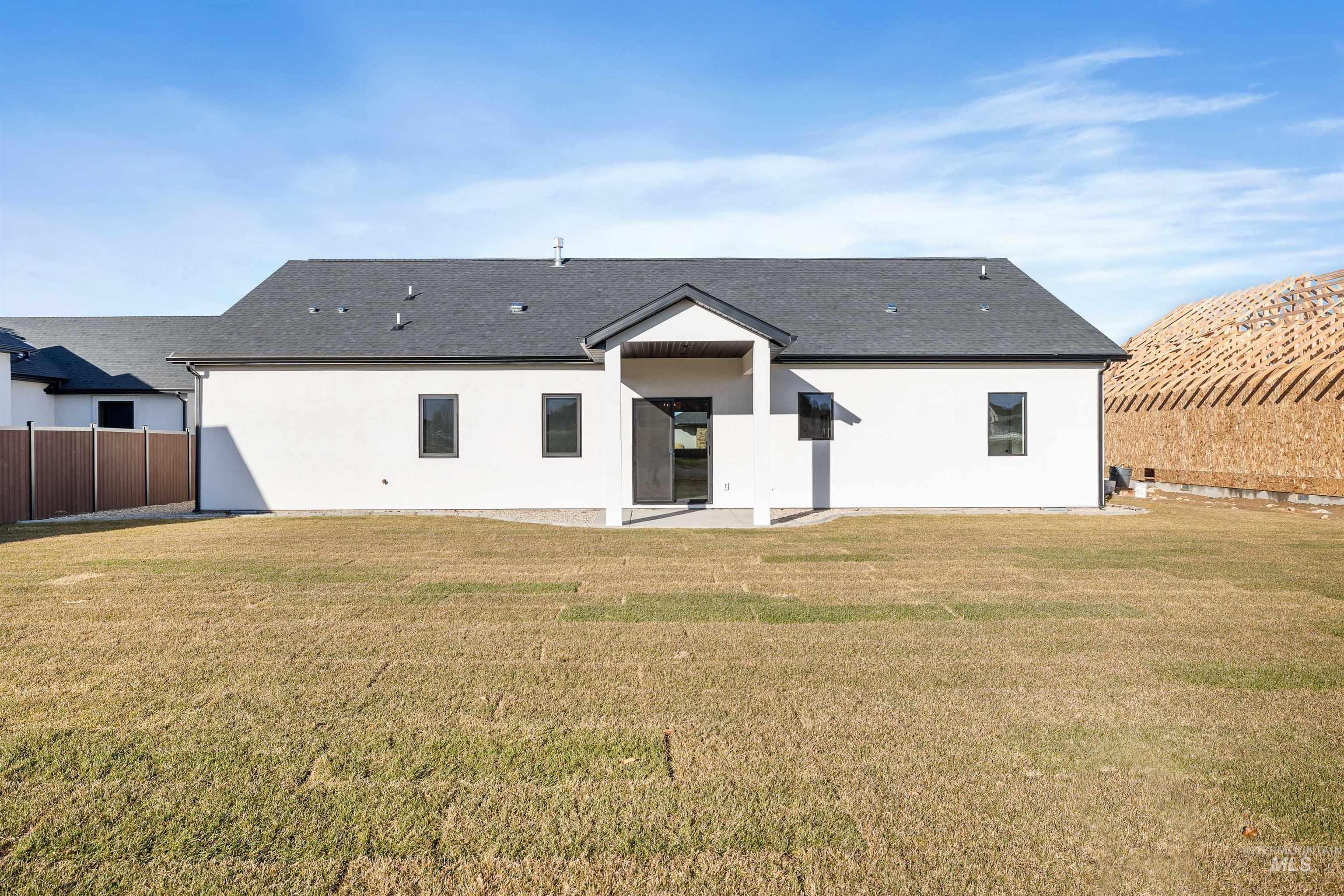 Back of property featuring a patio, stucco siding, and roof with shingles