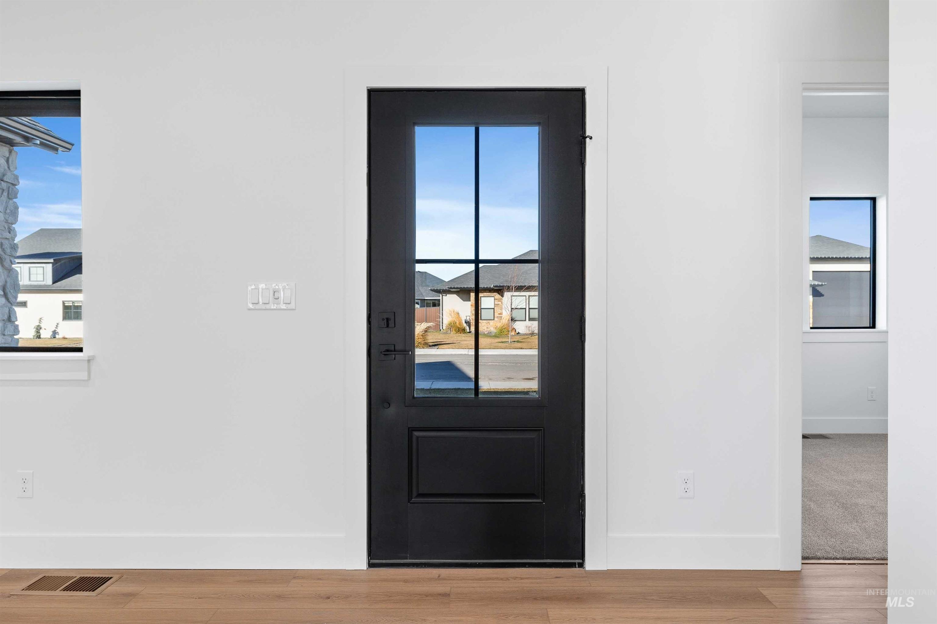 Doorway featuring baseboards and wood finished floors