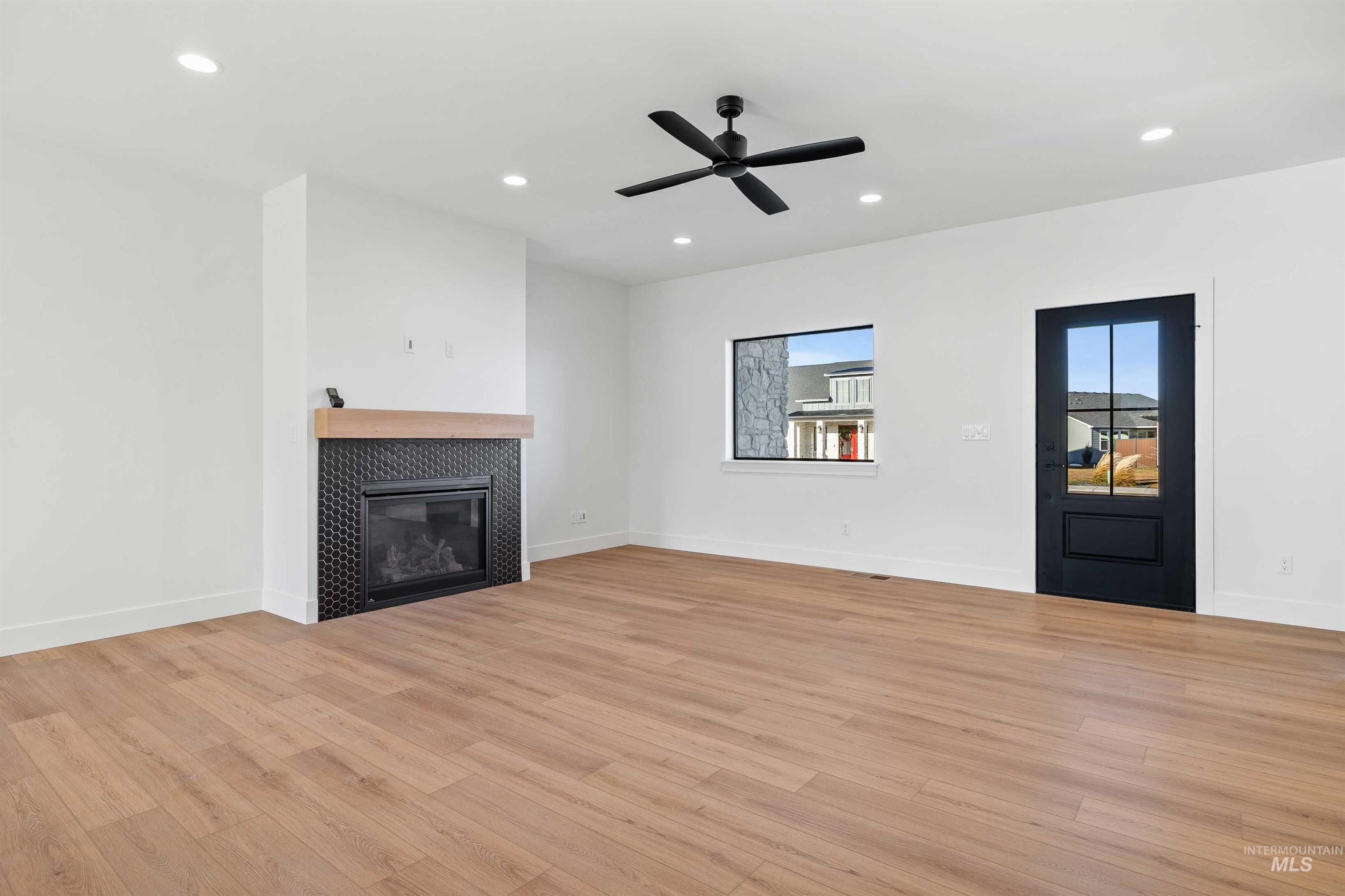 Unfurnished living room featuring light wood-type flooring, recessed lighting, a fireplace, and ceiling fan