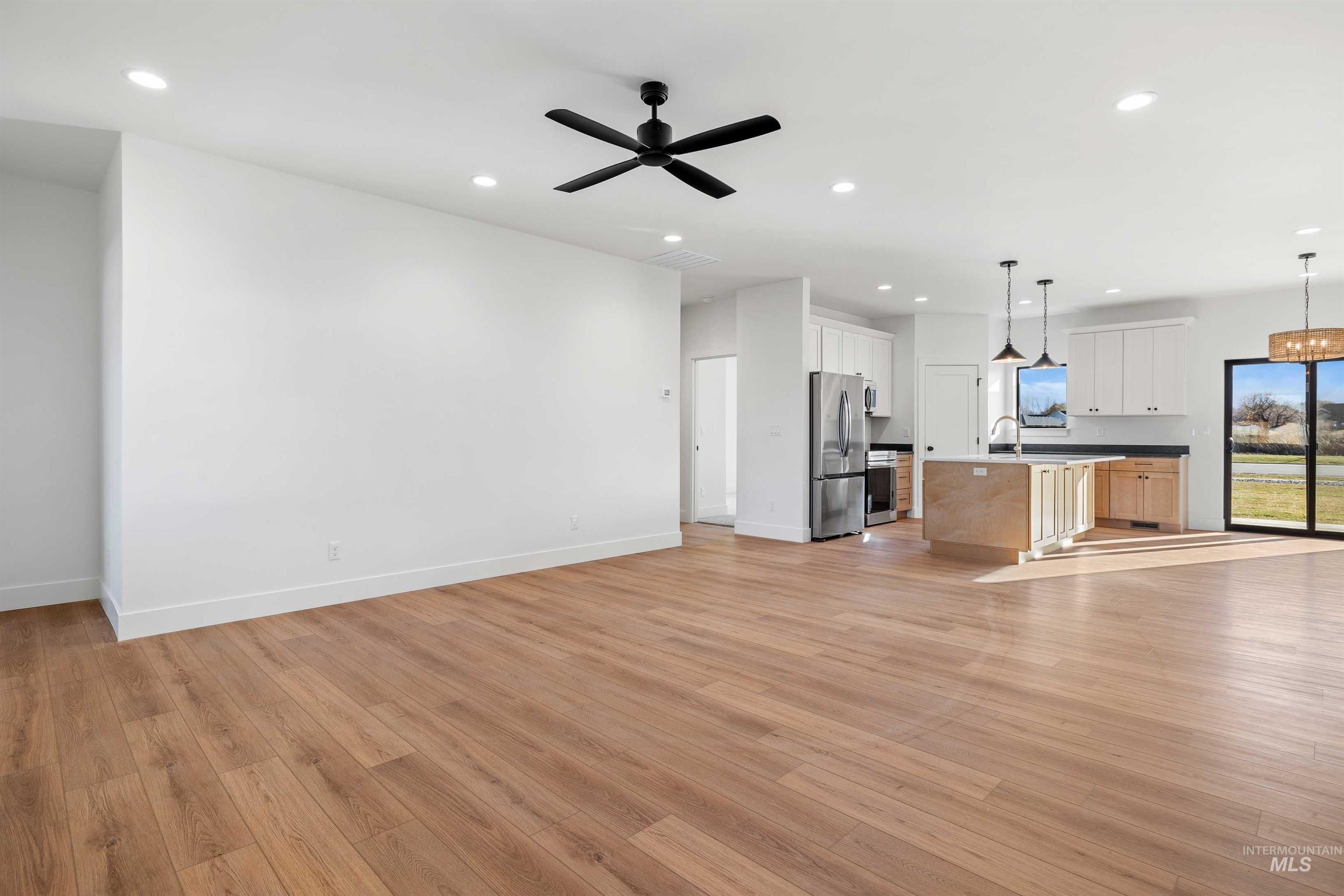 Unfurnished living room featuring light wood-style floors, recessed lighting, and ceiling fan