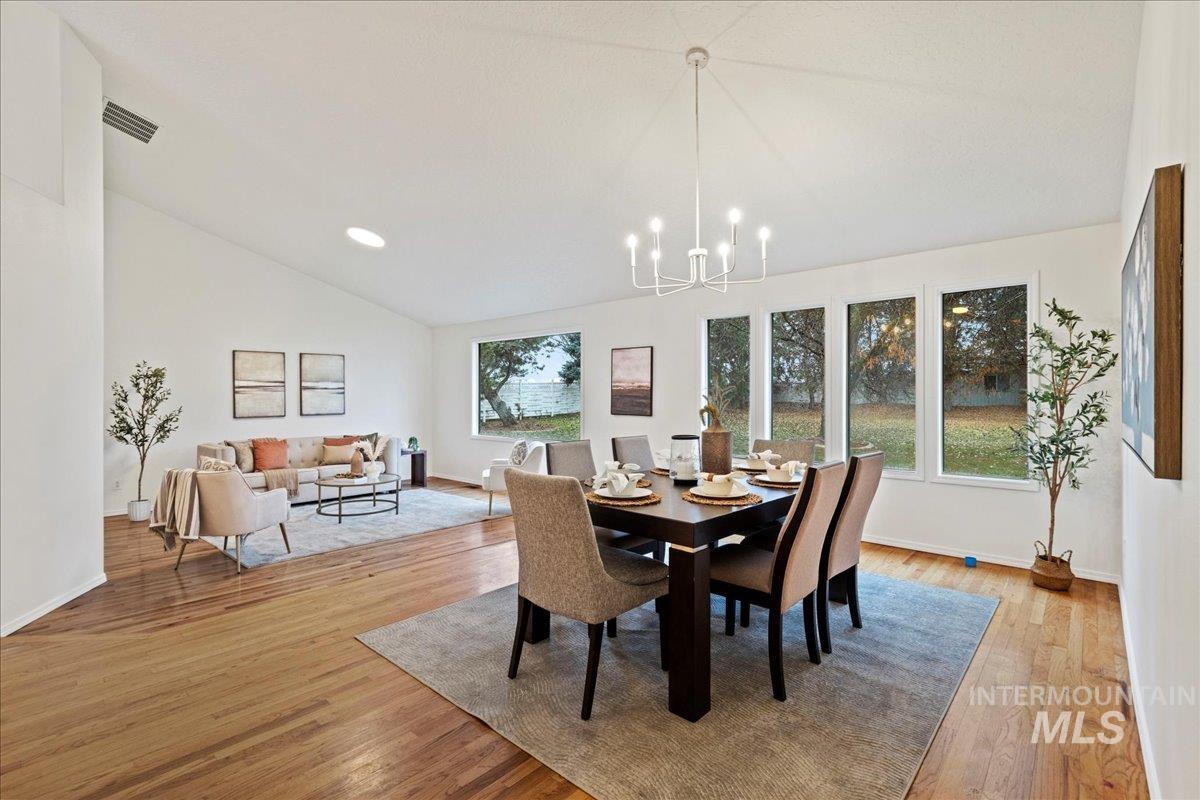 Dining space featuring lofted ceiling, light wood-type flooring, a chandelier, and recessed lighting