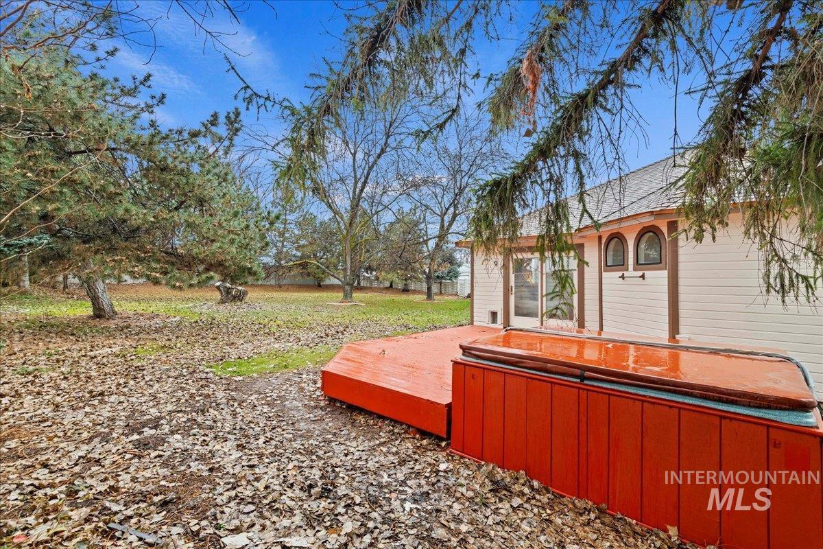View of yard featuring a hot tub and a deck