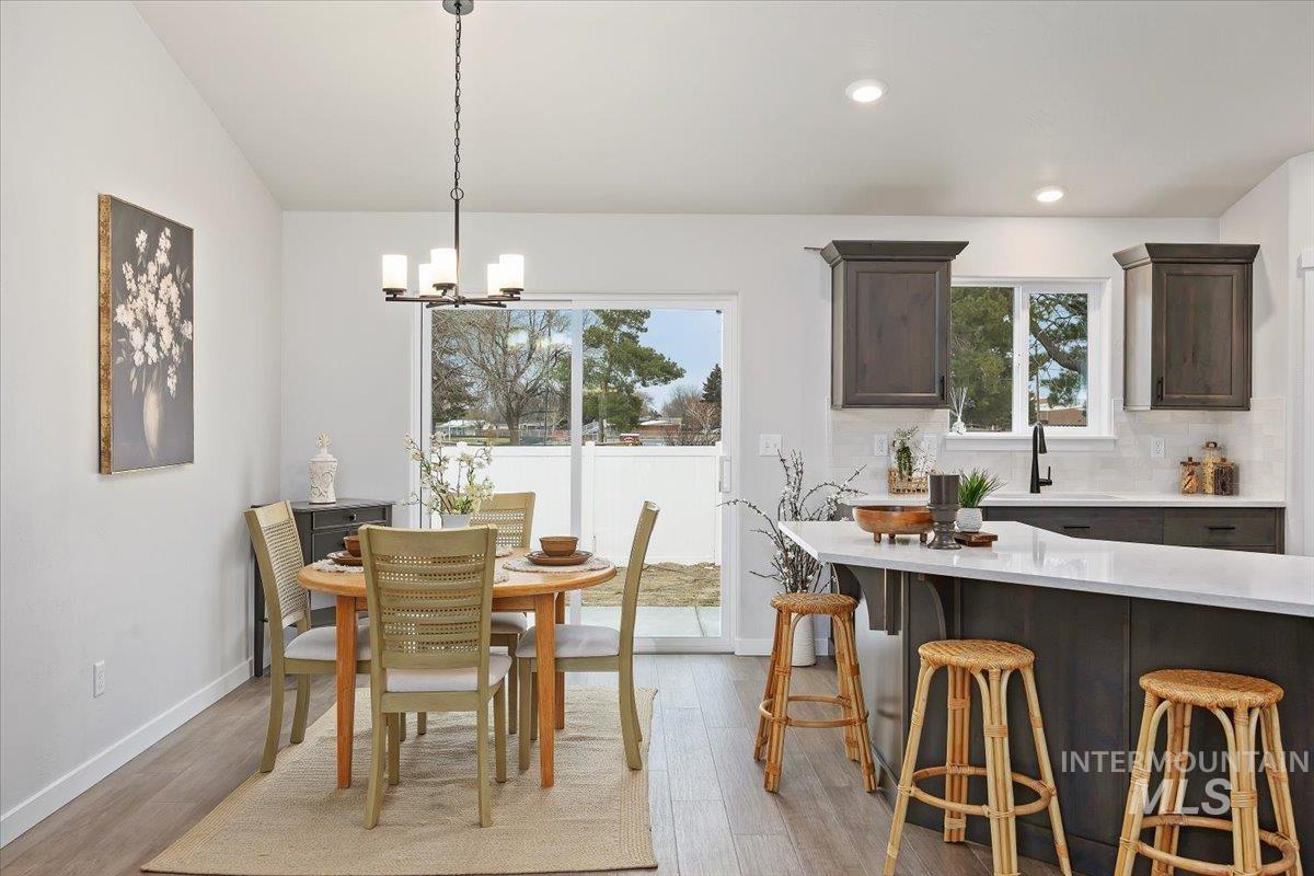 Dining area featuring light wood finished floors, a chandelier, and recessed lighting