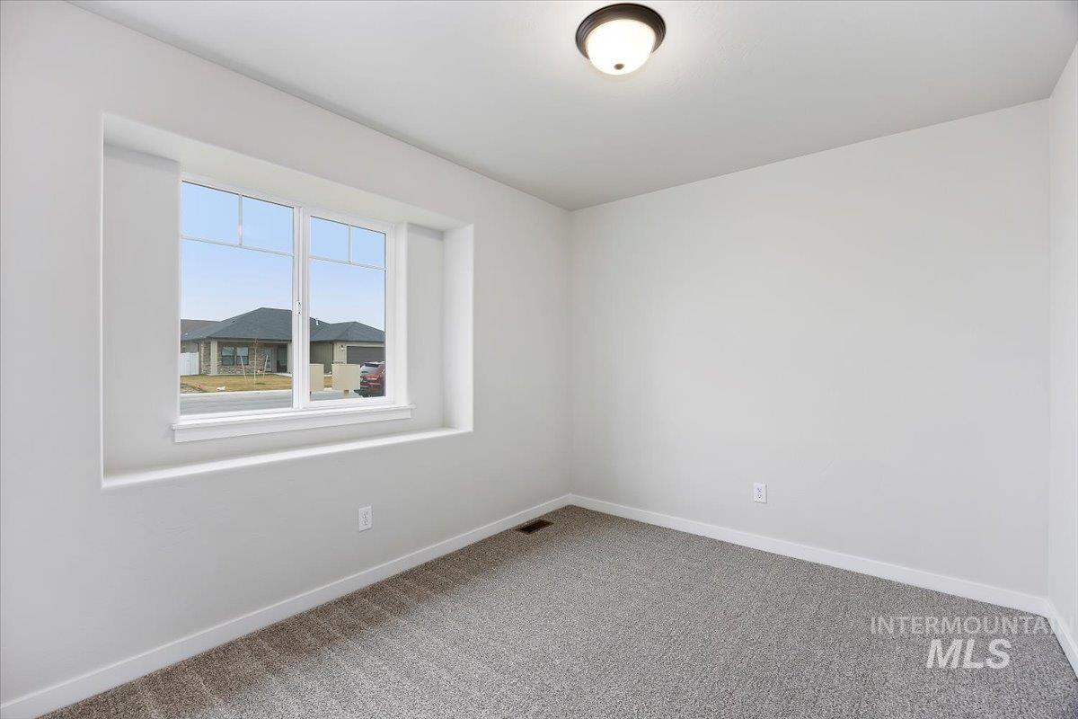 Carpeted empty room featuring baseboards