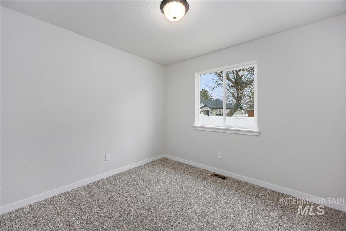 Unfurnished room featuring baseboards and light colored carpet
