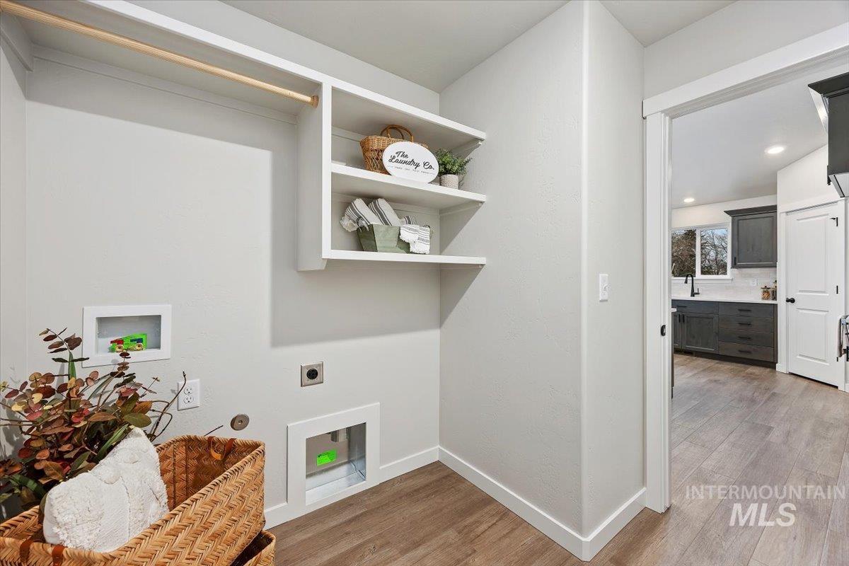 Laundry area with light wood-style floors, washer hookup, hookup for an electric dryer, and recessed lighting