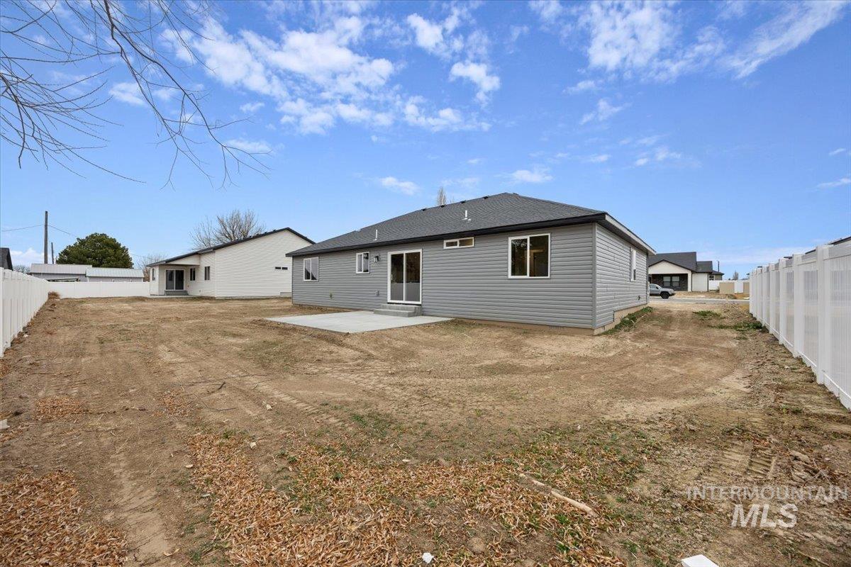 Rear view of house featuring a fenced backyard and a patio area