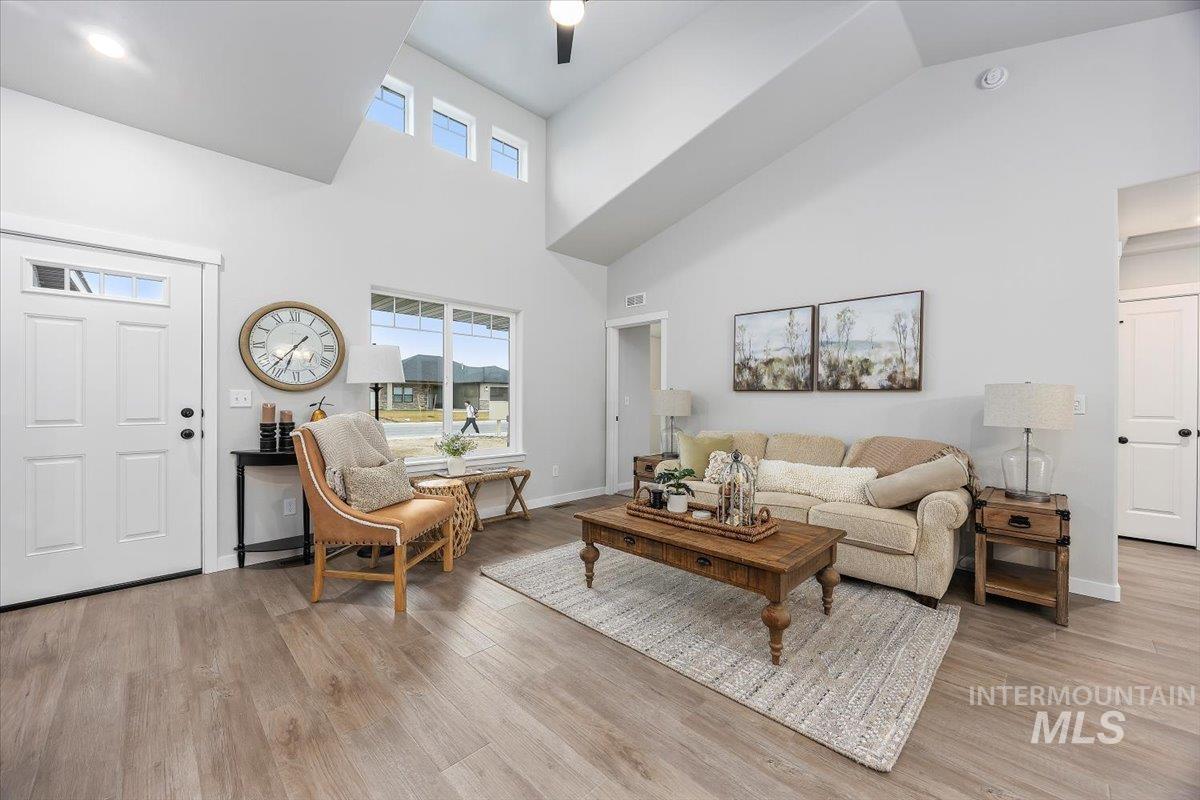 Living area featuring a towering ceiling and light wood finished floors