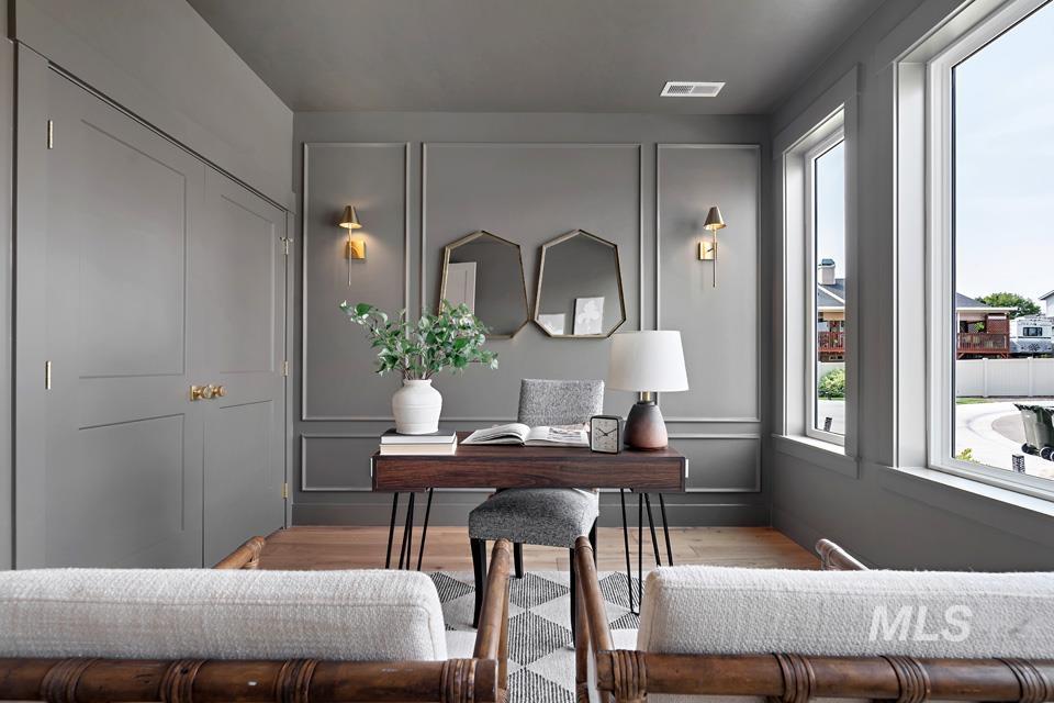 Office space with a decorative wall and wood finished floors