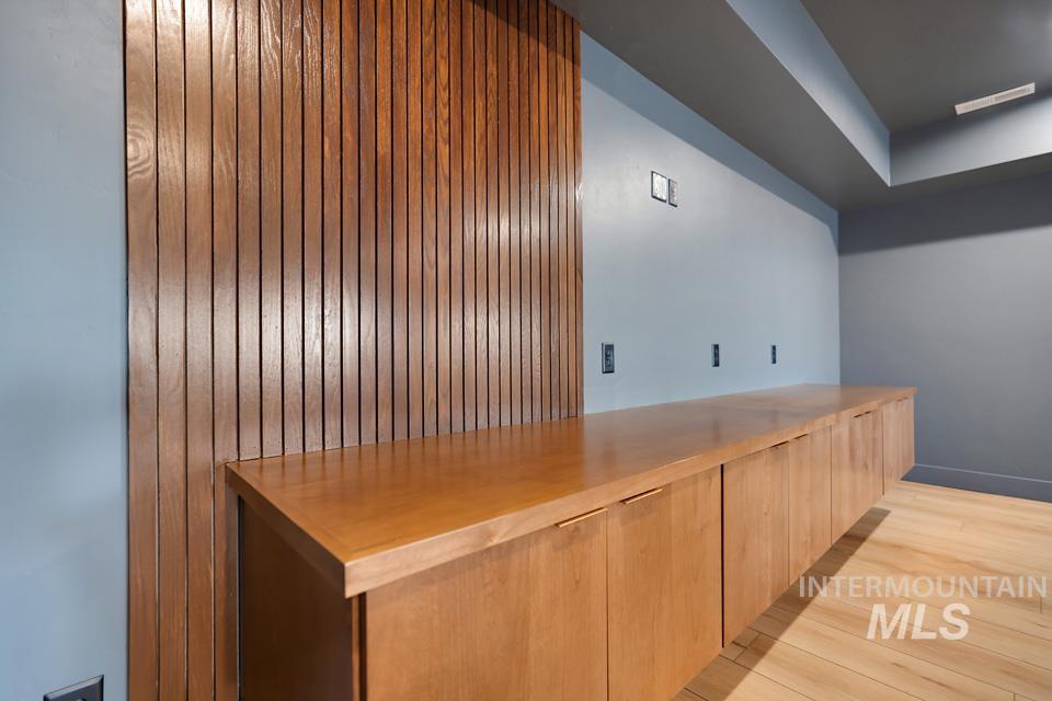 Bar area with modern cabinets, light wood-type flooring, and light brown cabinets