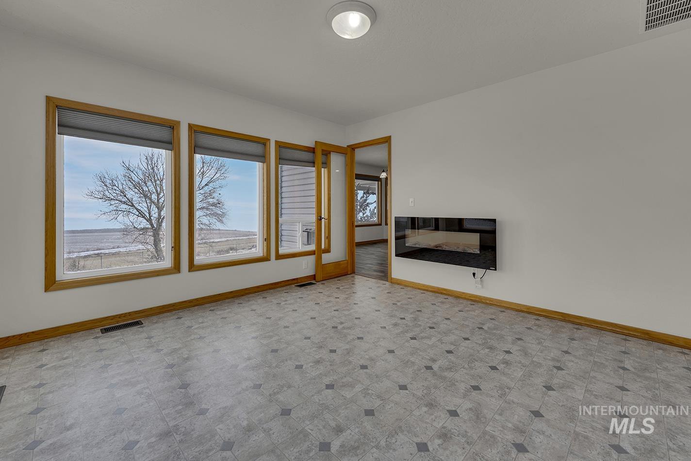 Unfurnished living room with baseboards and tile patterned floors