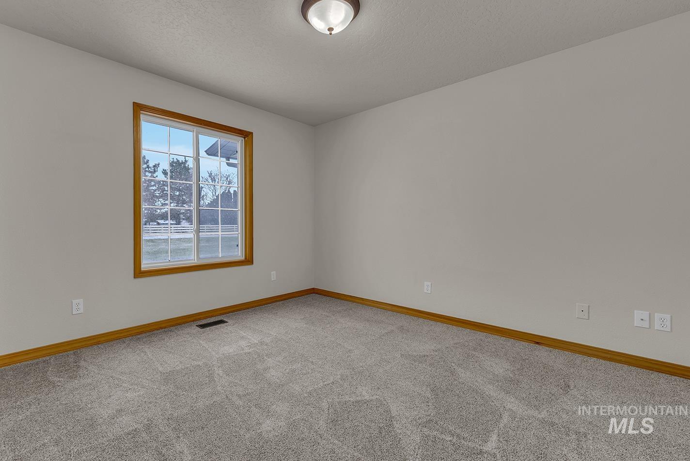 Empty room featuring light carpet and a textured ceiling