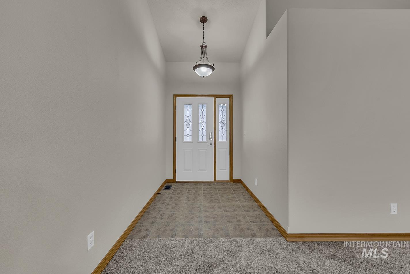 Entryway with carpet floors and baseboards