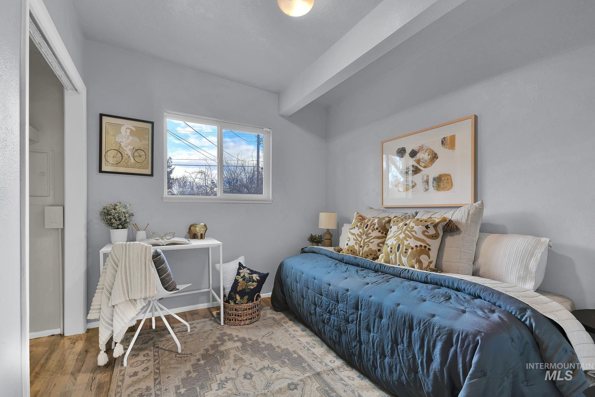 Bedroom featuring wood finished floors and baseboards