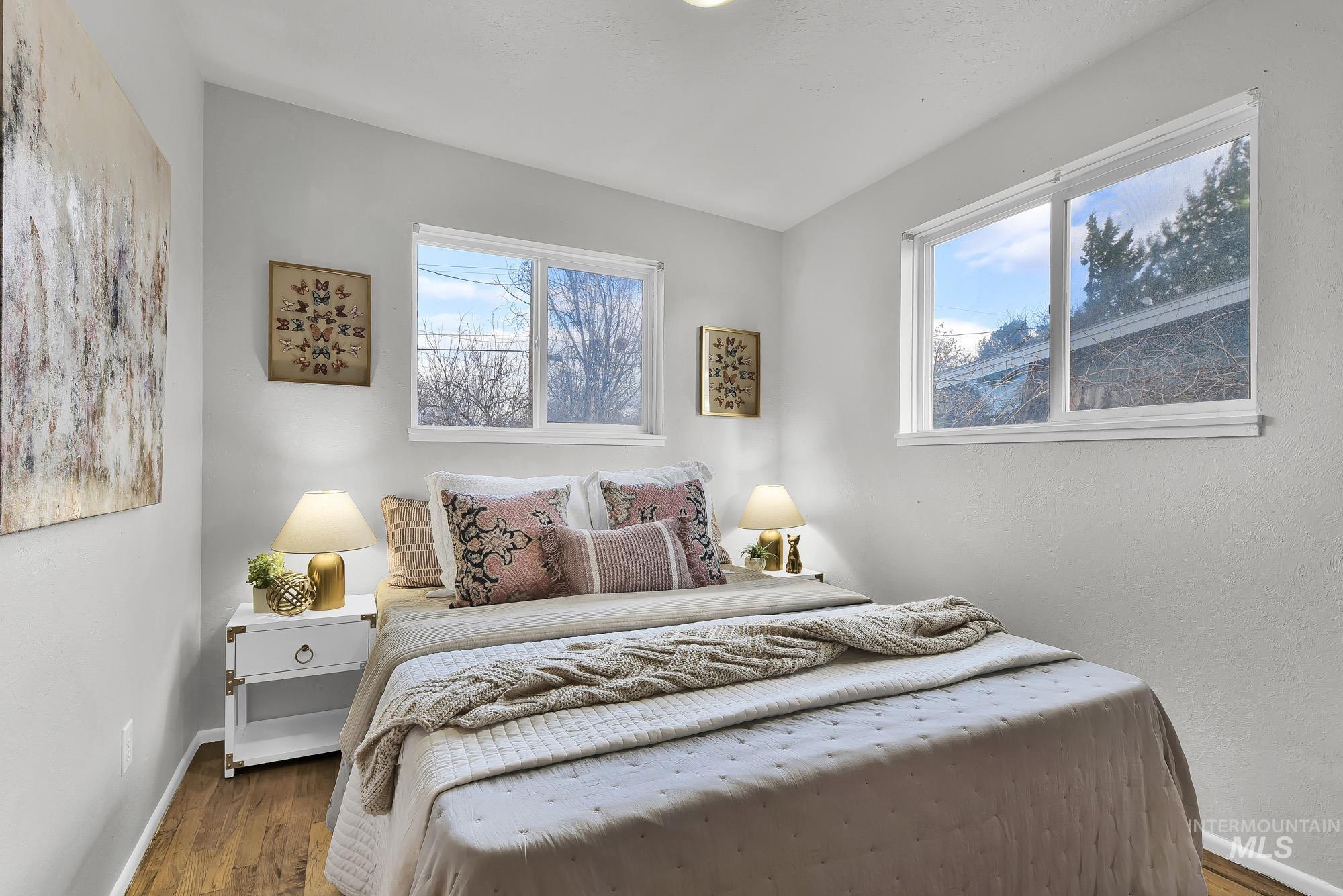 Bedroom with multiple windows and wood finished floors