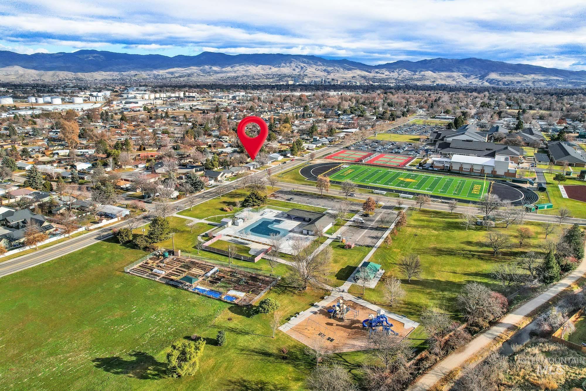 Aerial overview of property's location with a mountain backdrop and nearby suburban area
