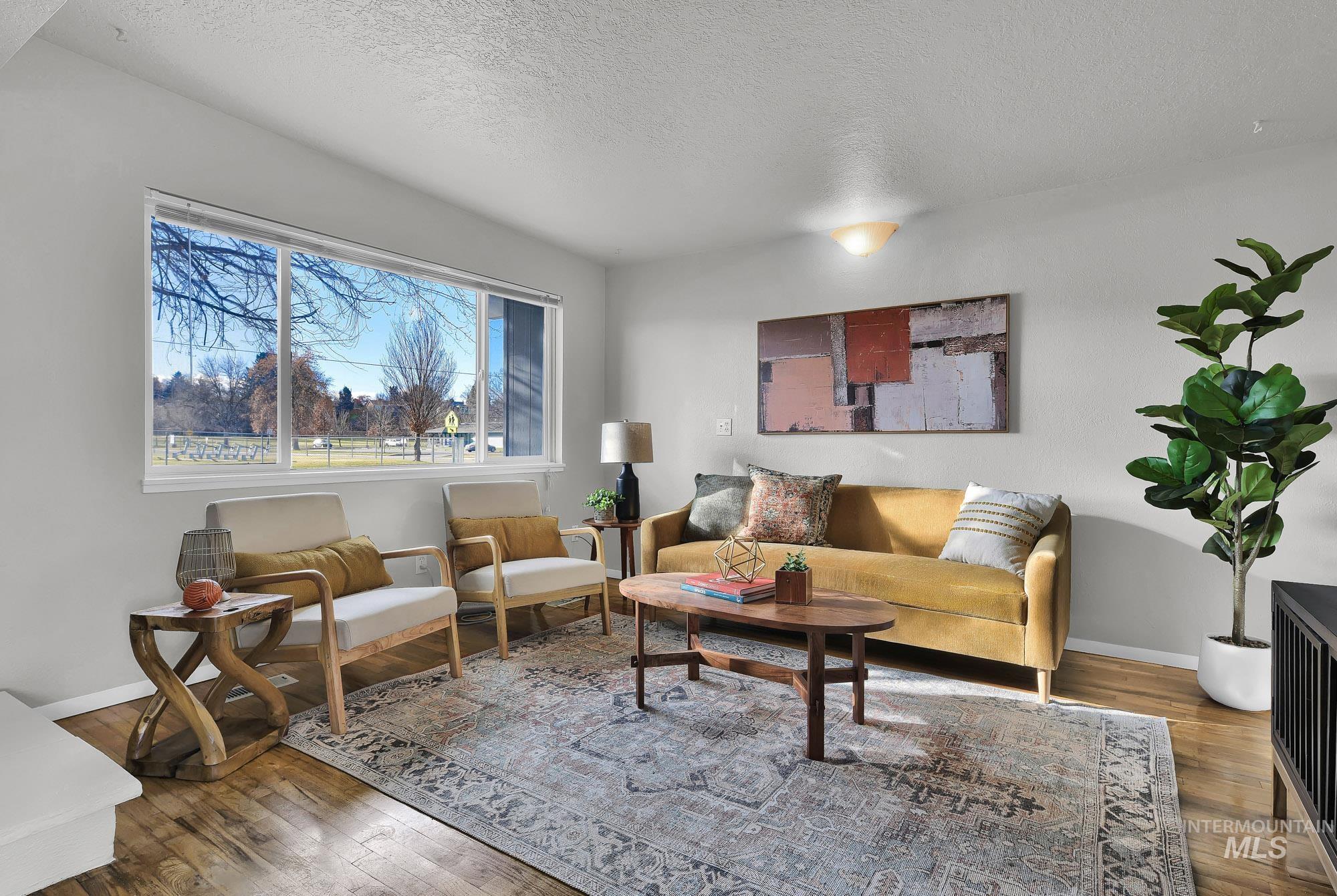 Living room with a textured ceiling and wood-type flooring