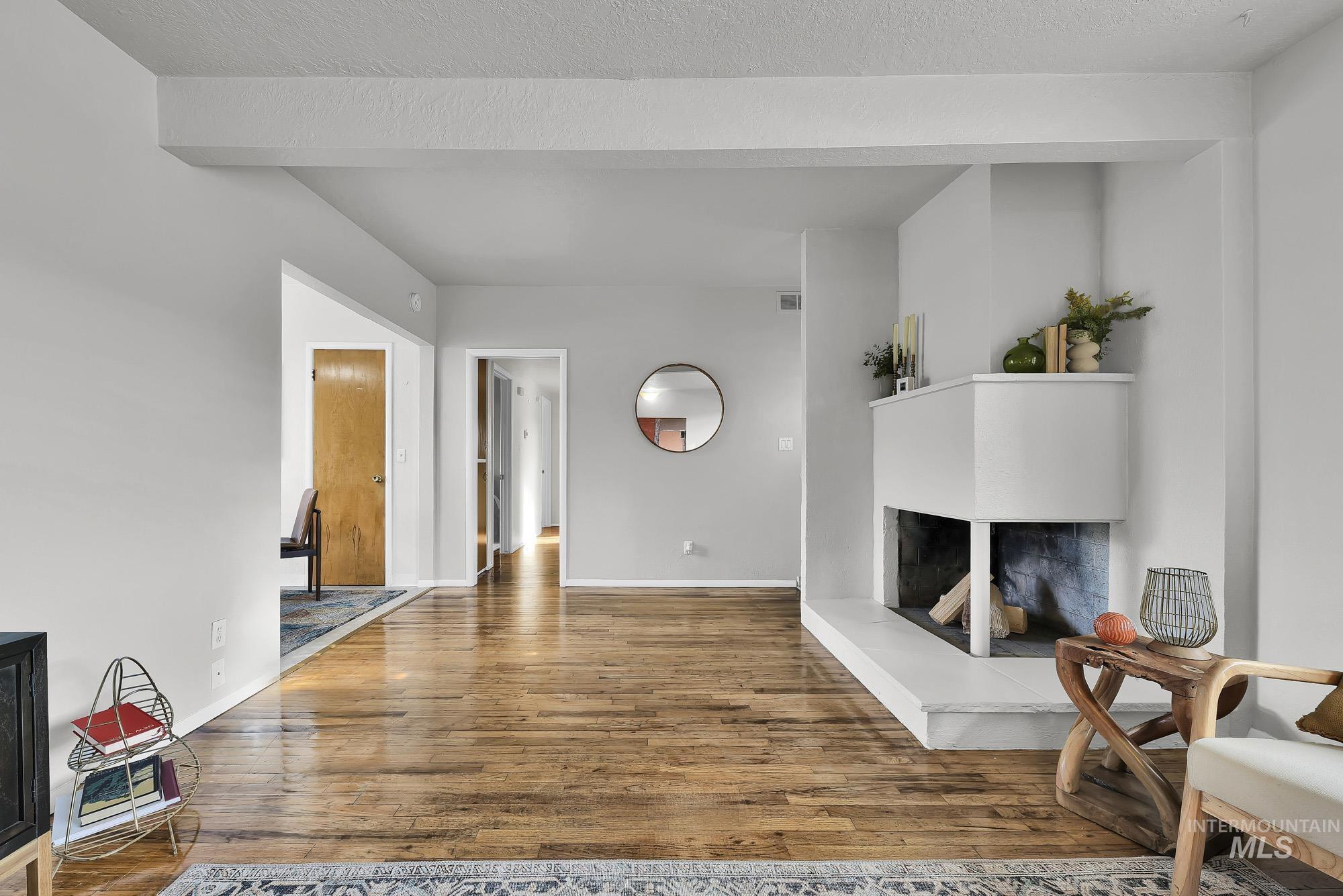 Living room featuring a multi sided fireplace and wood finished floors