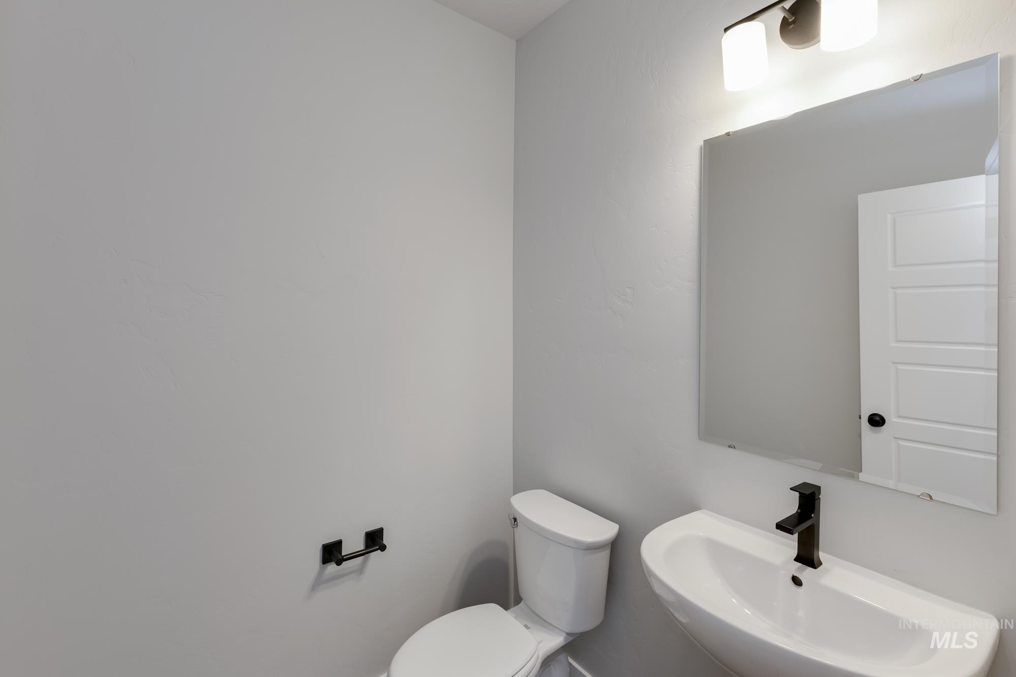 Half bath featuring a sink and toilet