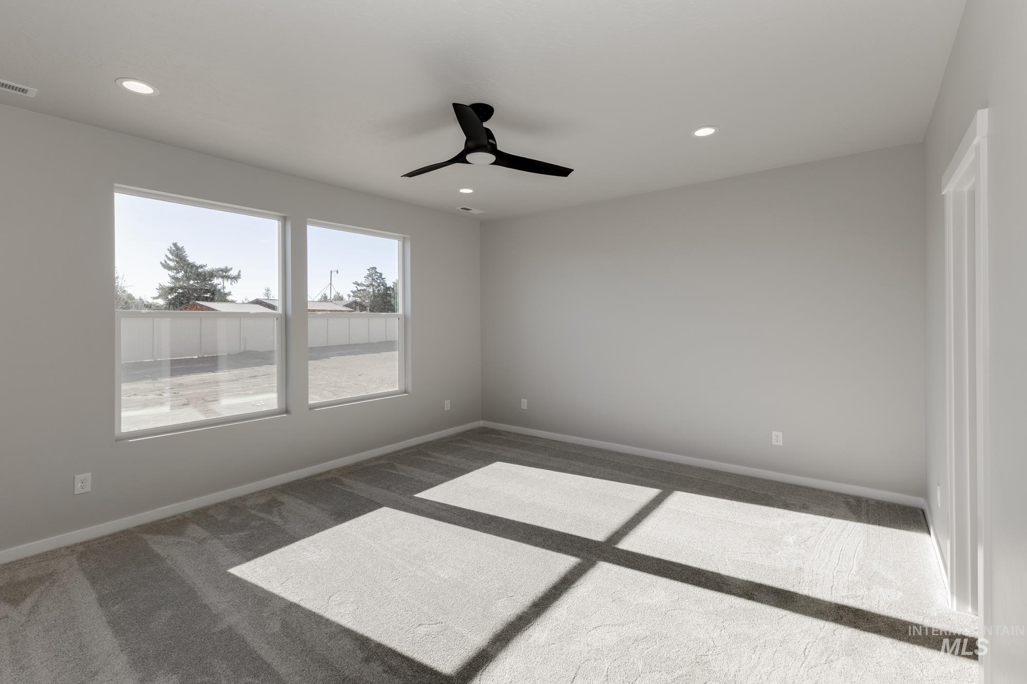Carpeted empty room with ceiling fan and recessed lighting