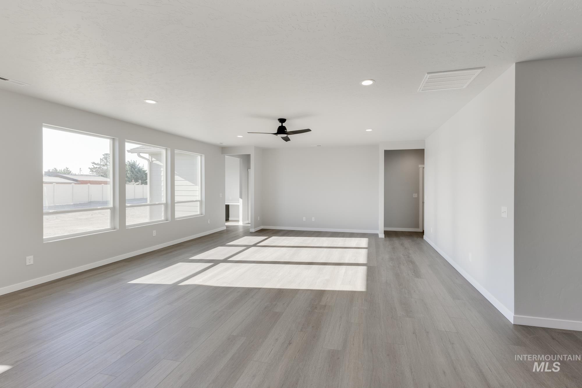 Spare room featuring light wood-style floors, a ceiling fan, and recessed lighting