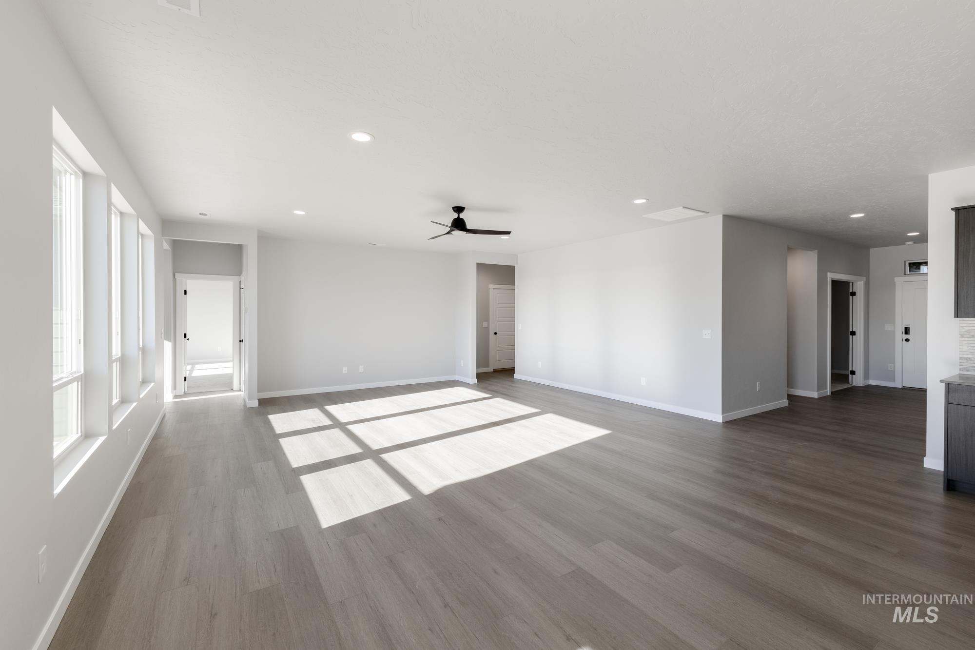 Unfurnished living room with wood finished floors, a ceiling fan, and recessed lighting