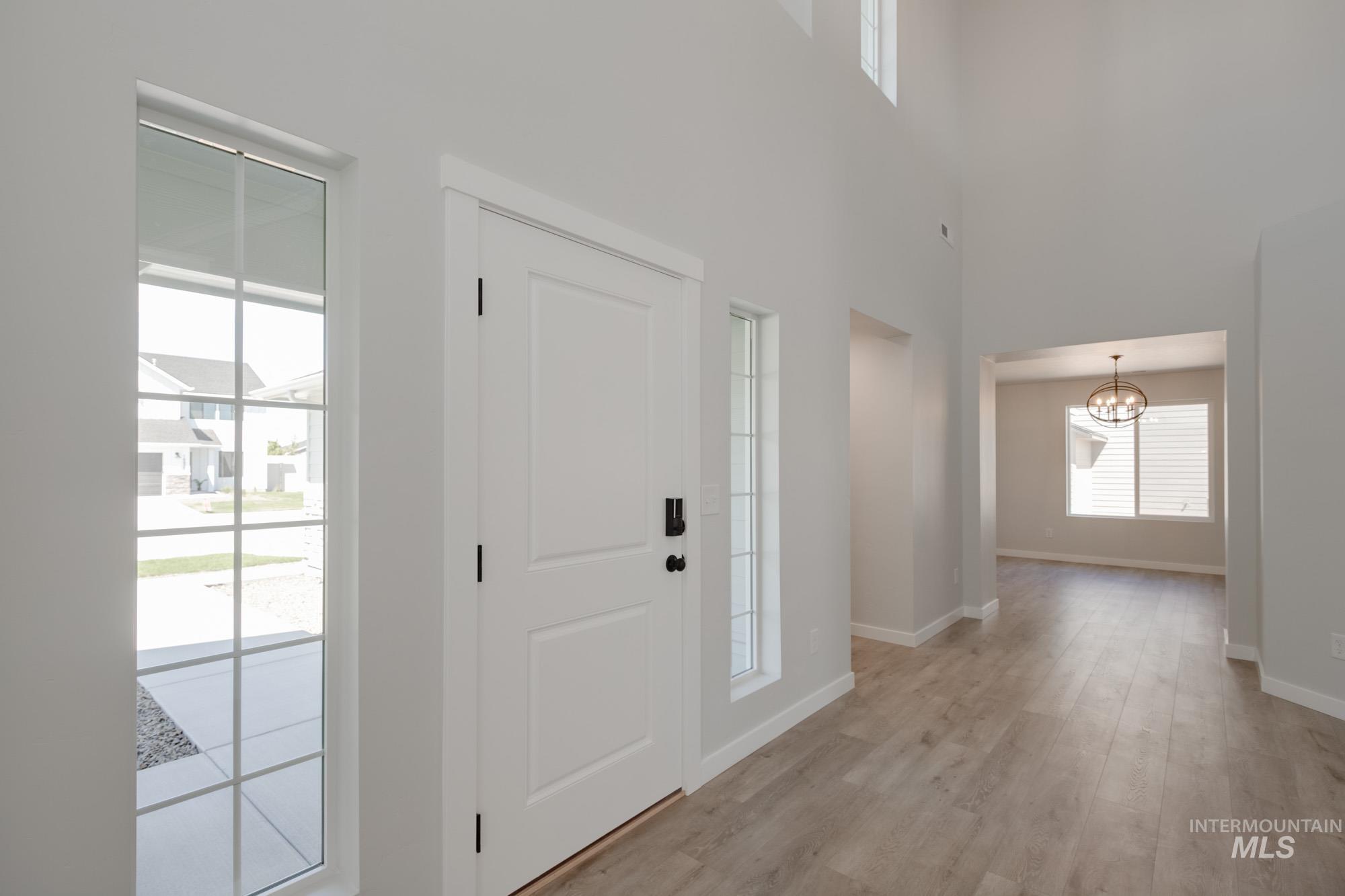 Entryway featuring light wood-style floors and a chandelier