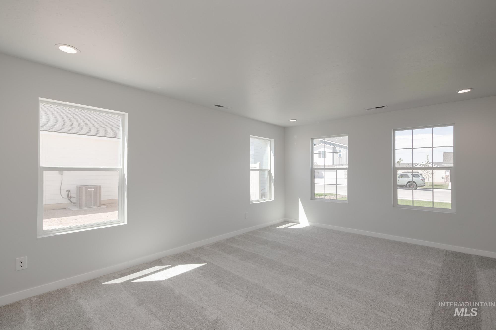 Carpeted spare room with baseboards and recessed lighting