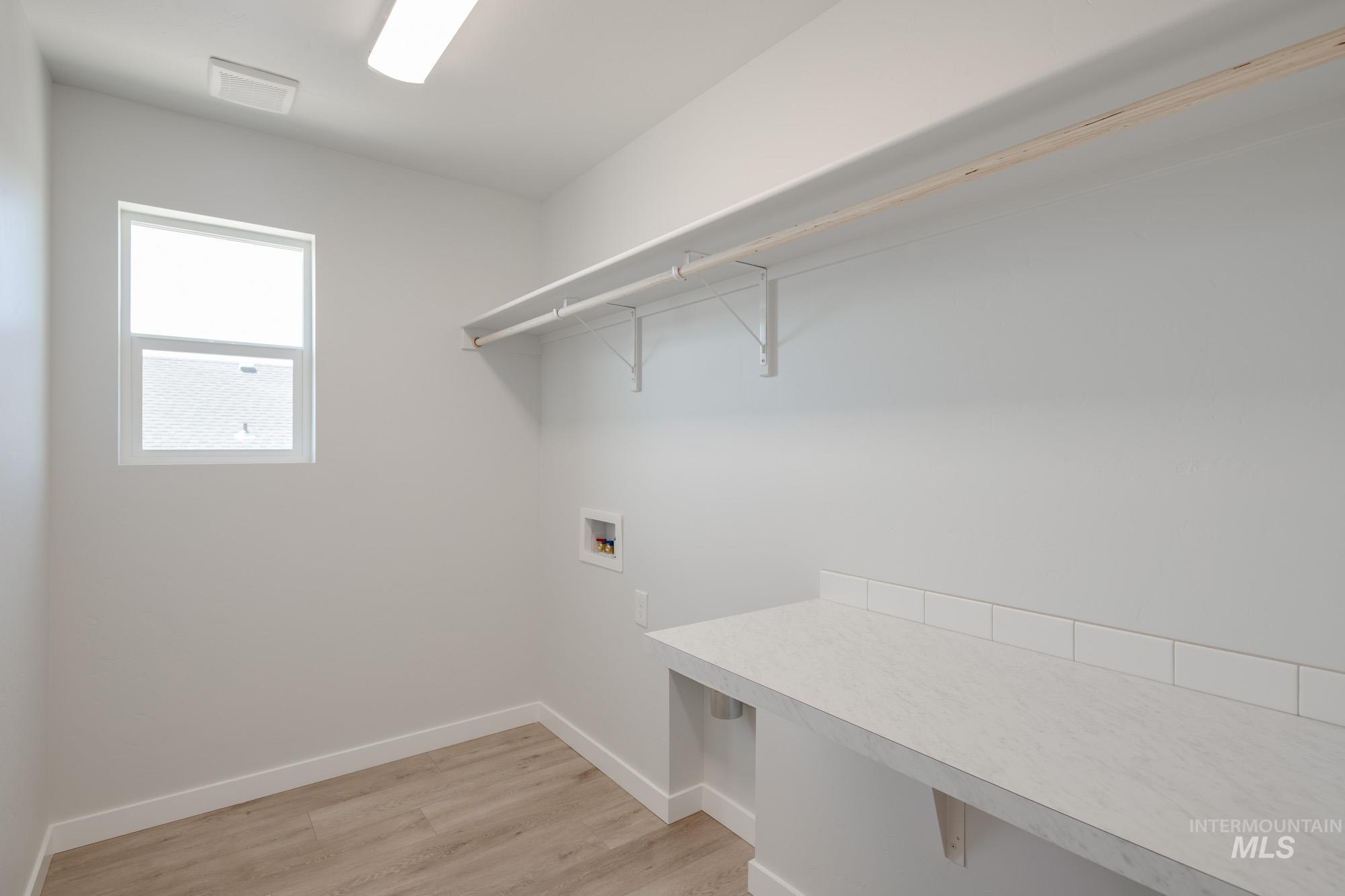 Washroom featuring washer hookup and light wood finished floors