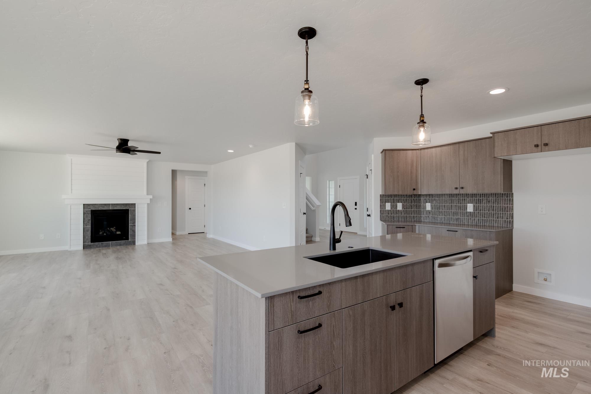 Kitchen featuring tasteful backsplash, hanging light fixtures, light wood-type flooring, open floor plan, and recessed lighting