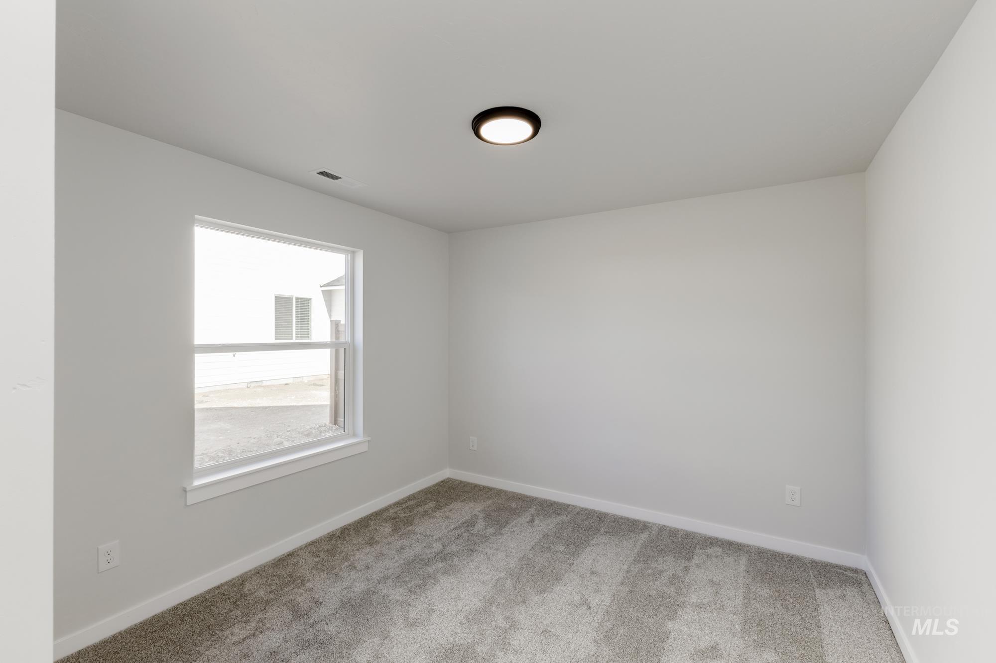 Unfurnished room featuring light carpet and baseboards