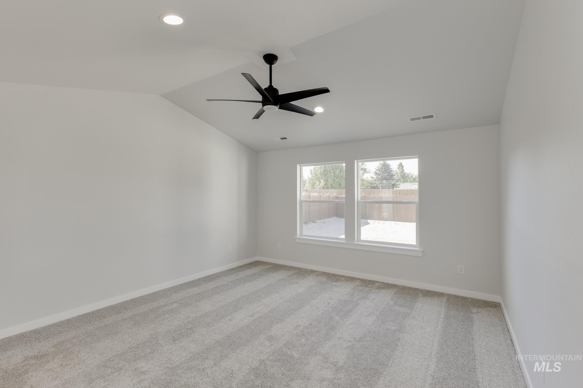 Spare room with light carpet, lofted ceiling, recessed lighting, and ceiling fan