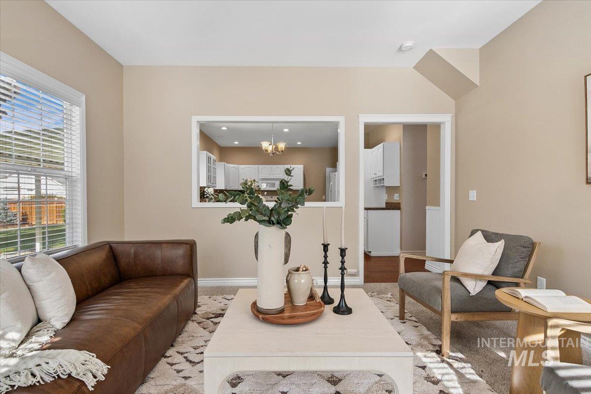 Living room featuring wood finished floors and a chandelier