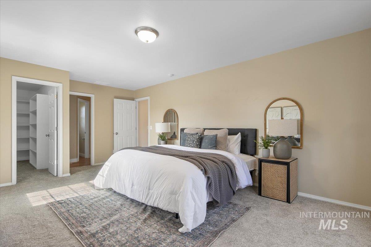 Bedroom featuring a walk in closet and light carpet