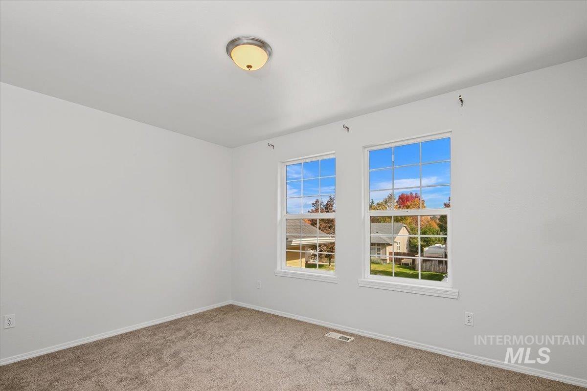 Spare room with light carpet and baseboards