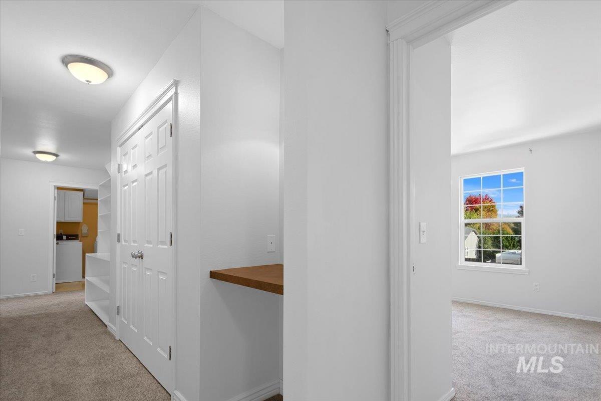 Hallway featuring light carpet and washer / clothes dryer