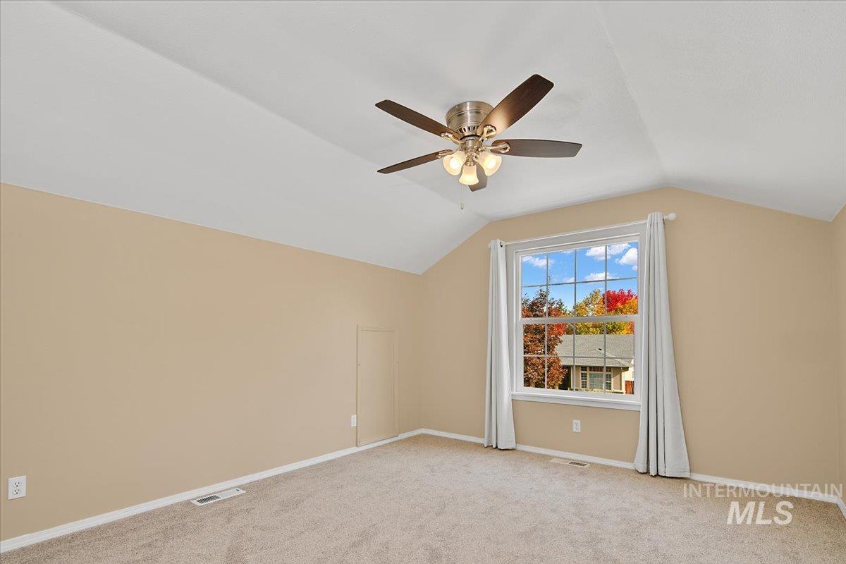 Bonus room featuring light colored carpet, vaulted ceiling, and ceiling fan