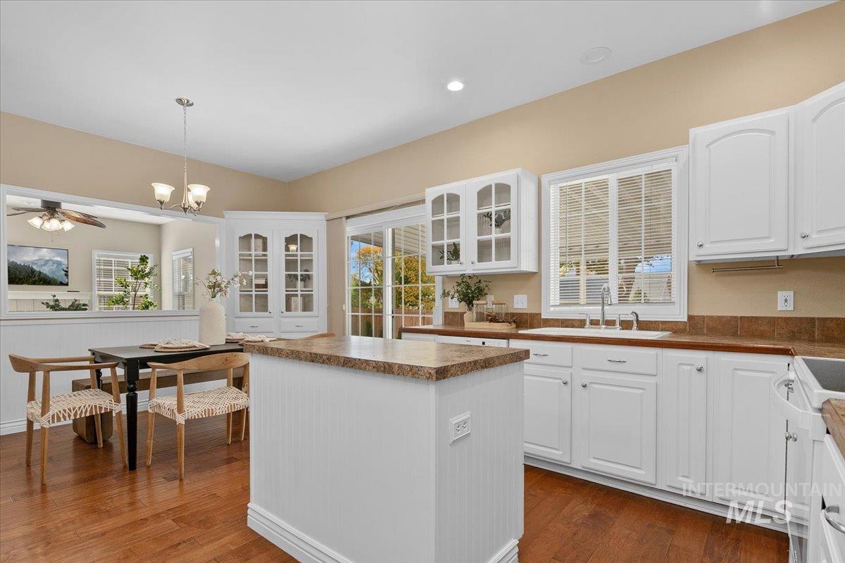Kitchen featuring a kitchen island, white cabinets, dark countertops, and recessed lighting