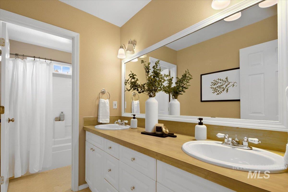 Bathroom featuring double vanity and shower / tub combo